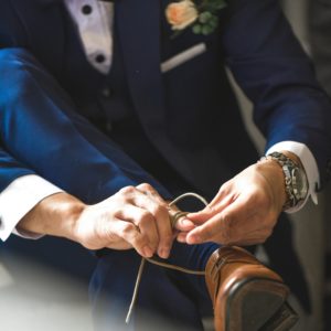 Cette image représente un homme lassant ses chaussures en position assise