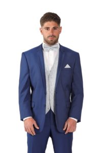 Cette image représente une personne portant un costume bleu indigo et un gilet de cérémonie à motifs écailles
